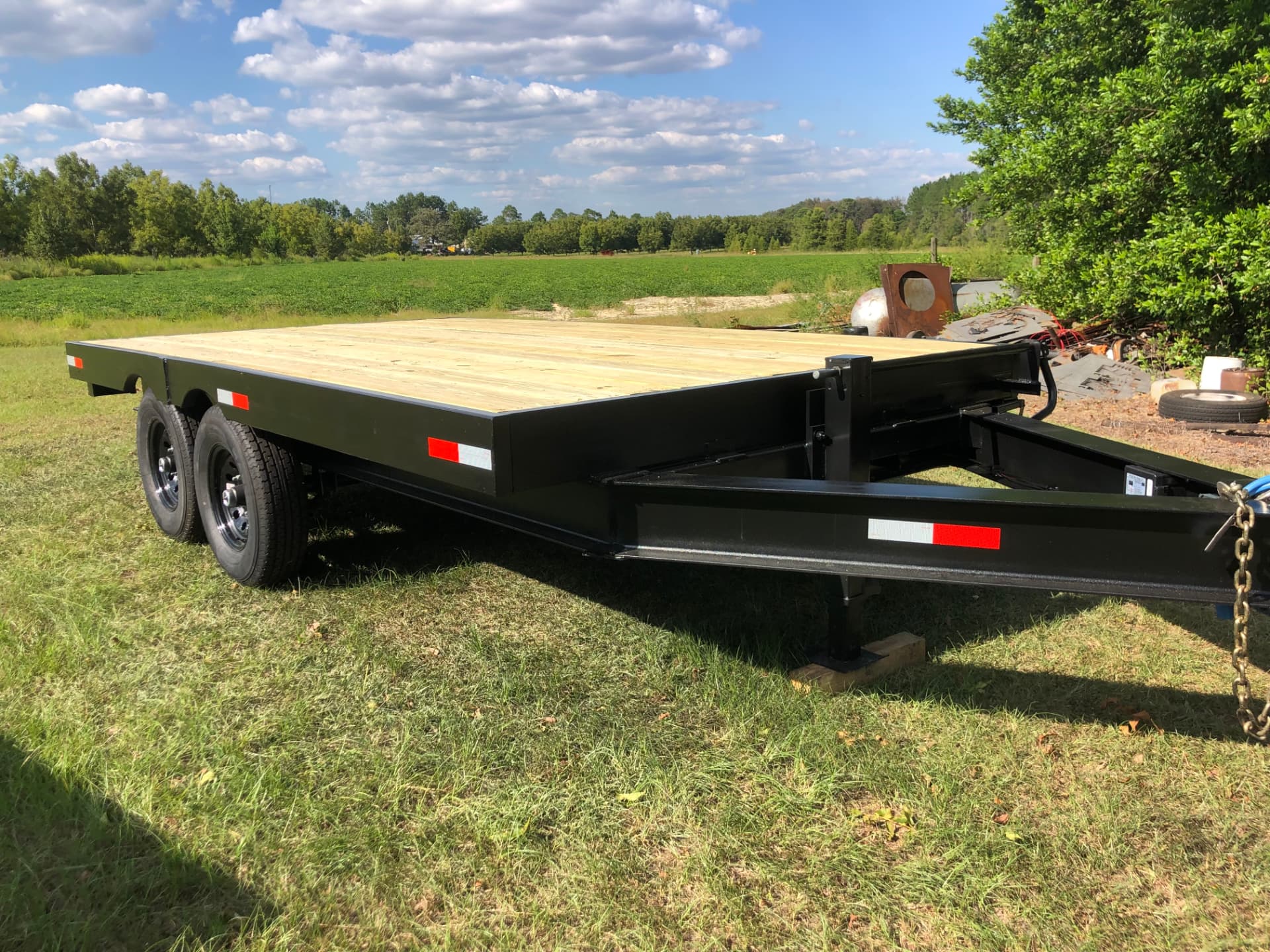 Custom built black tandem axle flatbed trailer with wood deck