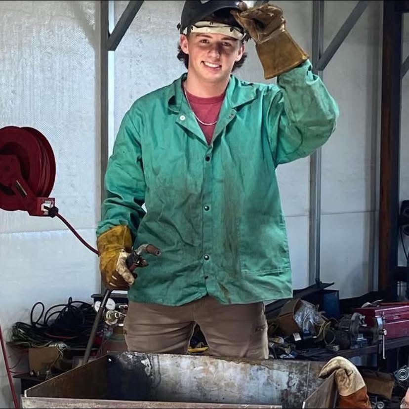 Logan James in welding gear at the James Fabrication shop